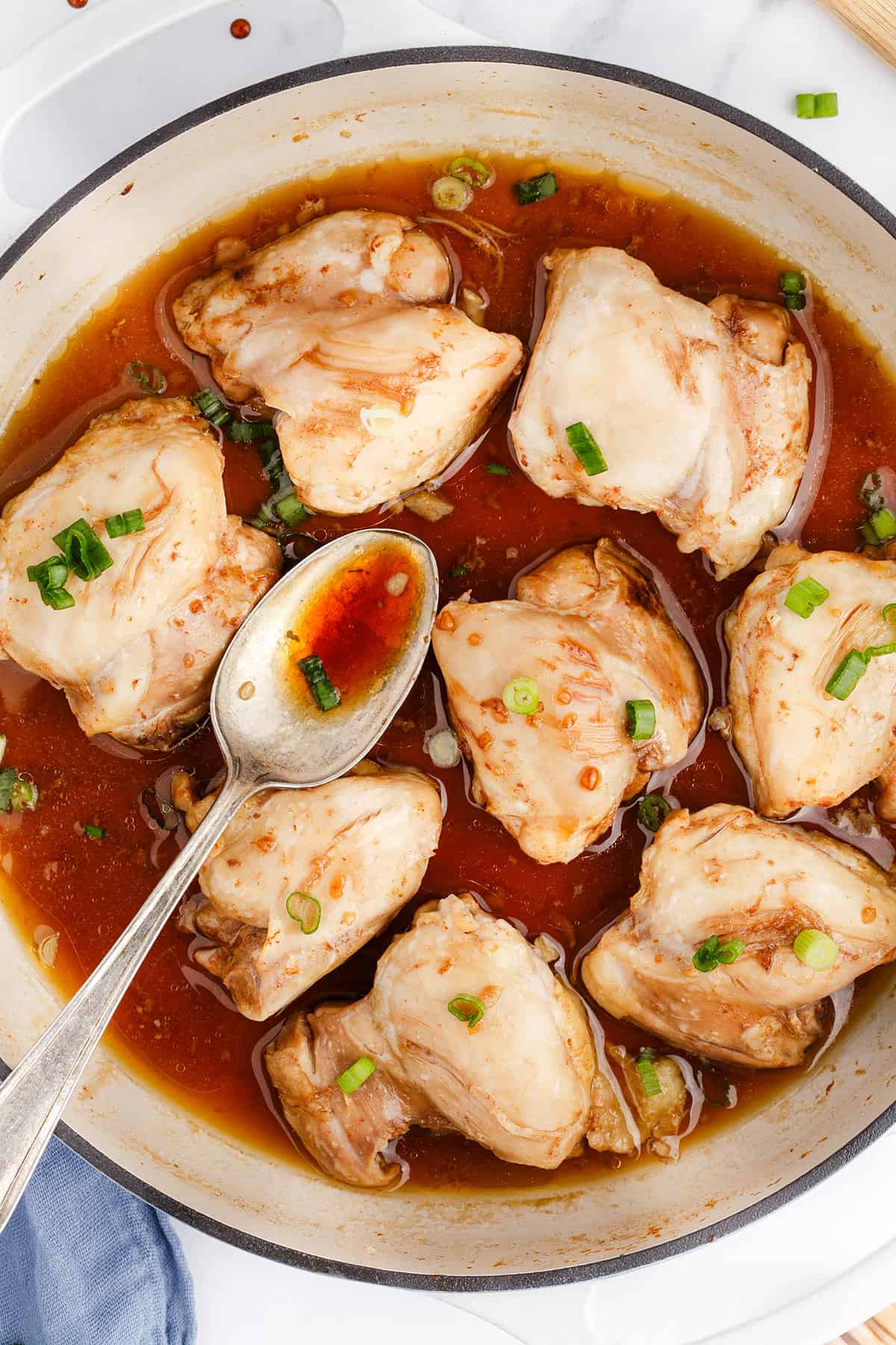 Chicken Thighs with Honey in a Pan with a Spoon