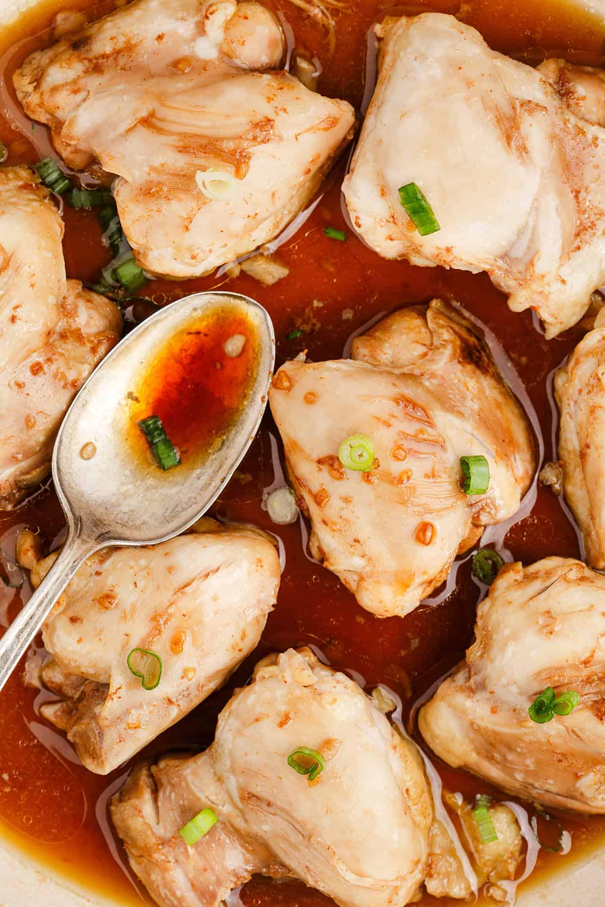 Chicken Thighs with Honey in a Pan with a Spoon