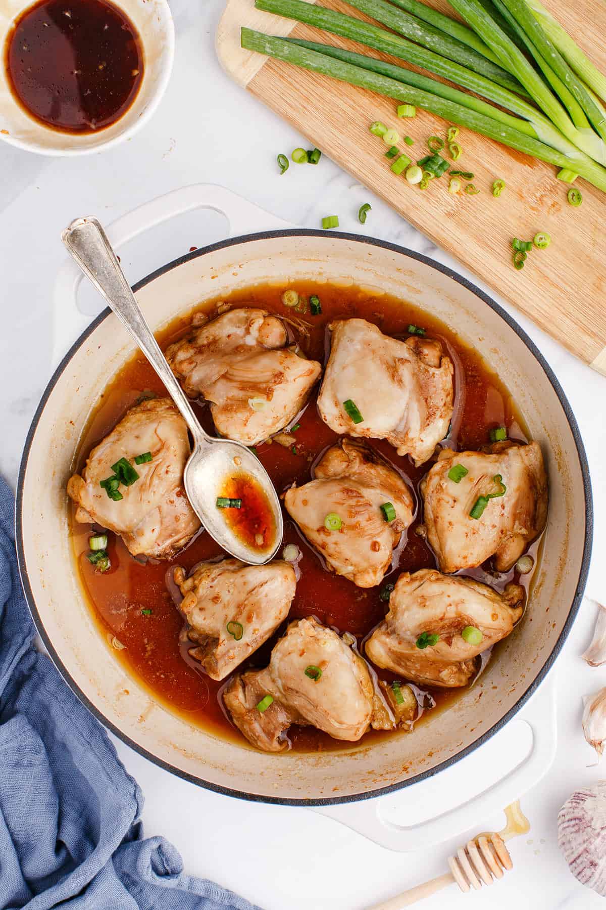 Chicken Thighs with Honey in a Pan with a Spoon