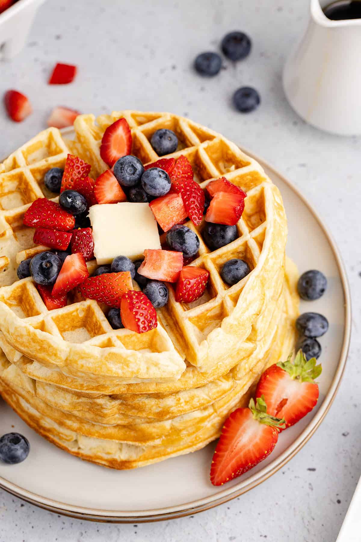 Gluten Free Buttermilk Waffles Stacked On a Plate With Berries