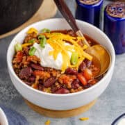 Stove Top Chili in a Bowl Garnished with Sour Cream, Cheese and Green Onion