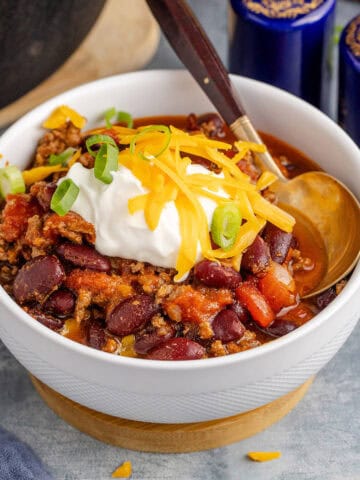 Stove Top Chili in a Bowl Garnished with Sour Cream, Cheese and Green Onion