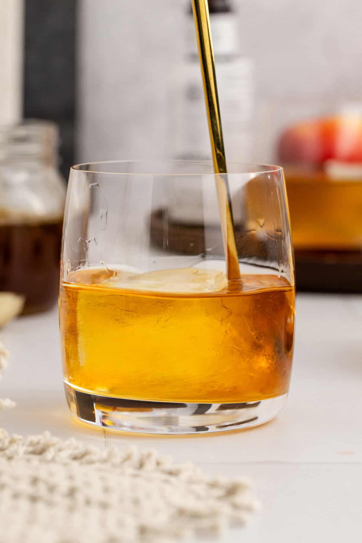 Apple Cider Old Fashioned being Stirred with Ice in Glass