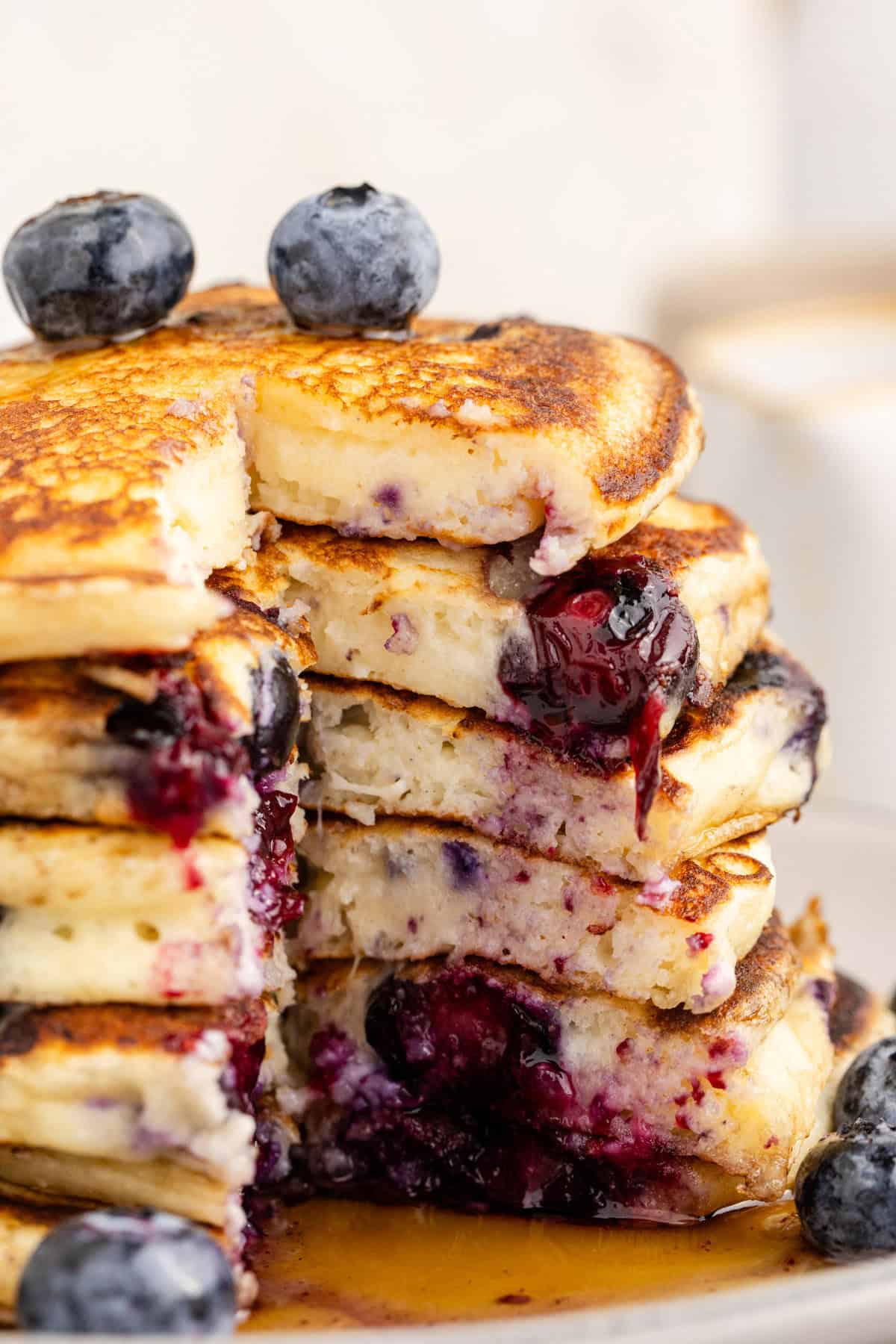 Blueberry Buttermilk Pancakes on a Plate with Syrup Slice Taken out