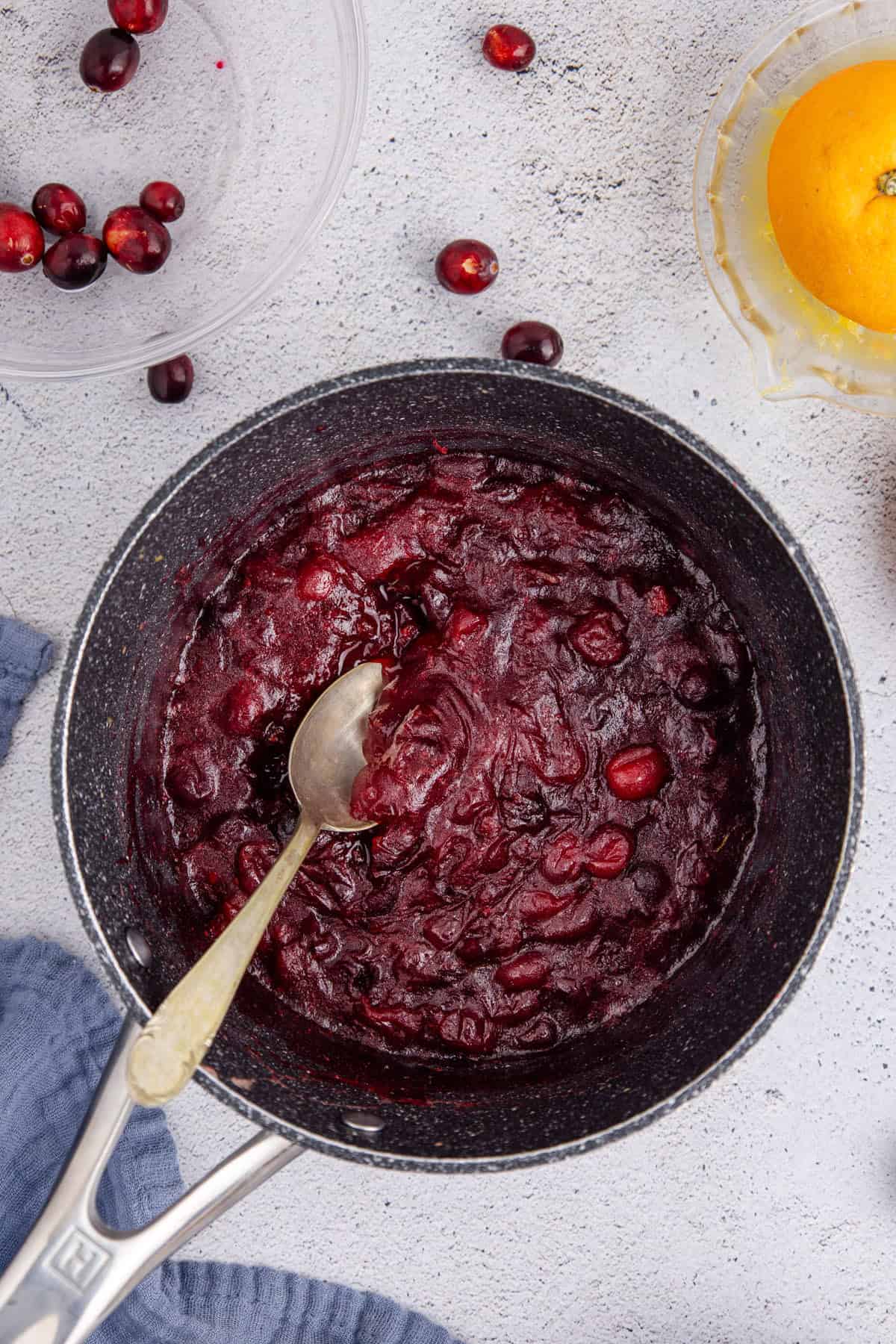 Whole Berry Cranberry Sauce in a Pot with a Spoon