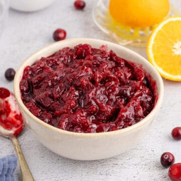 Whole Berry Cranberry Sauce in a Bowl with a Spoon Beside