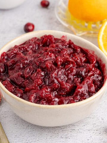 Whole Berry Cranberry Sauce in a Bowl with a Spoon Beside