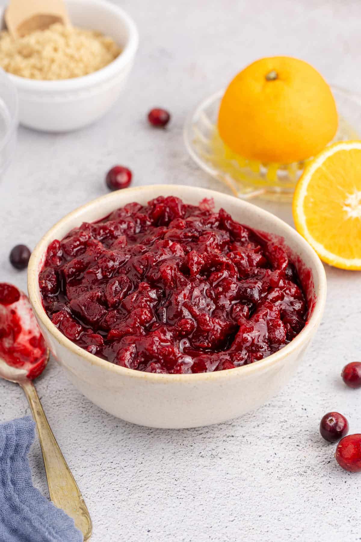 Whole Berry Cranberry Sauce in a Bowl with a Spoon Beside