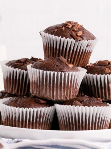 Double Chocolate Chunk Muffins Stacked on a Plate