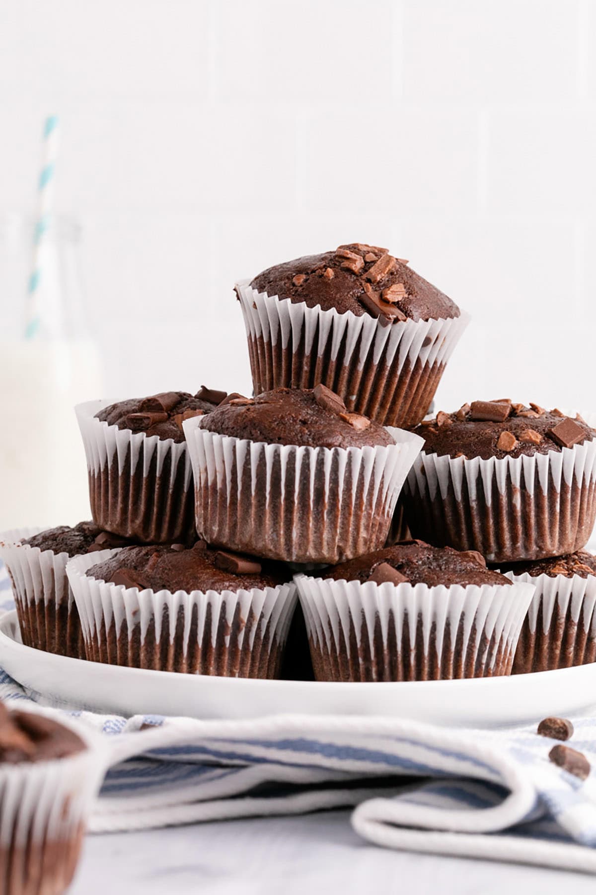 Double Chocolate Chunk Muffins Stacked on a Plate