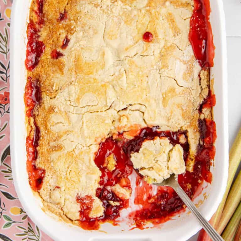 Strawberry Rhubarb Dump Cake Scoop in Casserole Dish