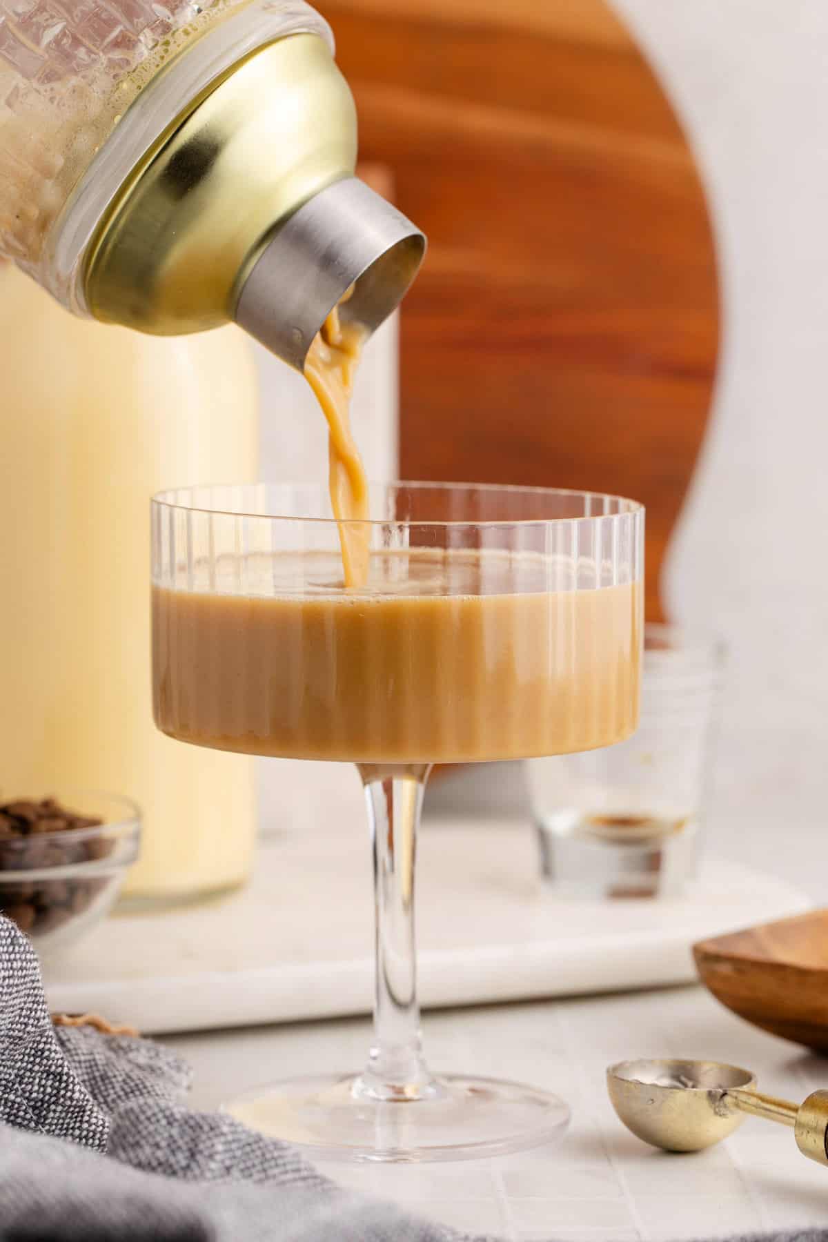 Eggnog Espresso Martini Being Poured into a Coupe Glass