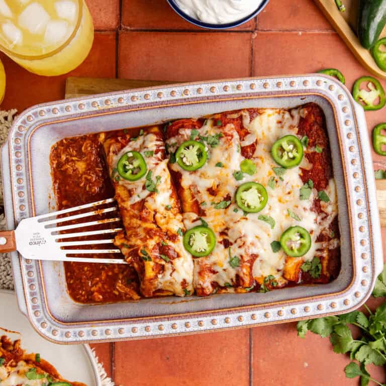 Enchiladas baked and being scooped out of dish