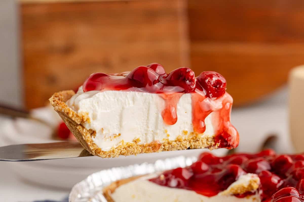 Cherry Cheesecake Pie on a pie server being served