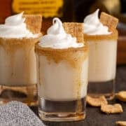 Cinnamon Toast Crunch Shots garnished with whipped cream and a golden graham cereal piece