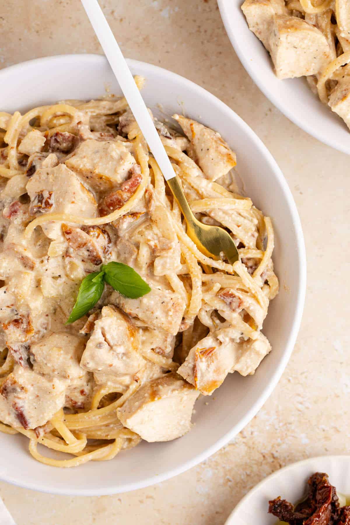 Creamy Sun Dried Tomato Chicken Pasta with a fork in a bowl