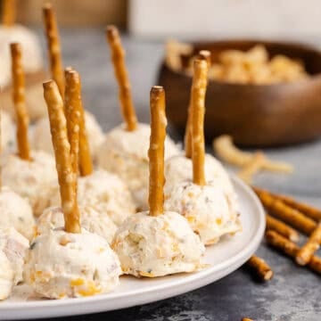 Mini Cheese Balls close up on a plate with pretzels beside