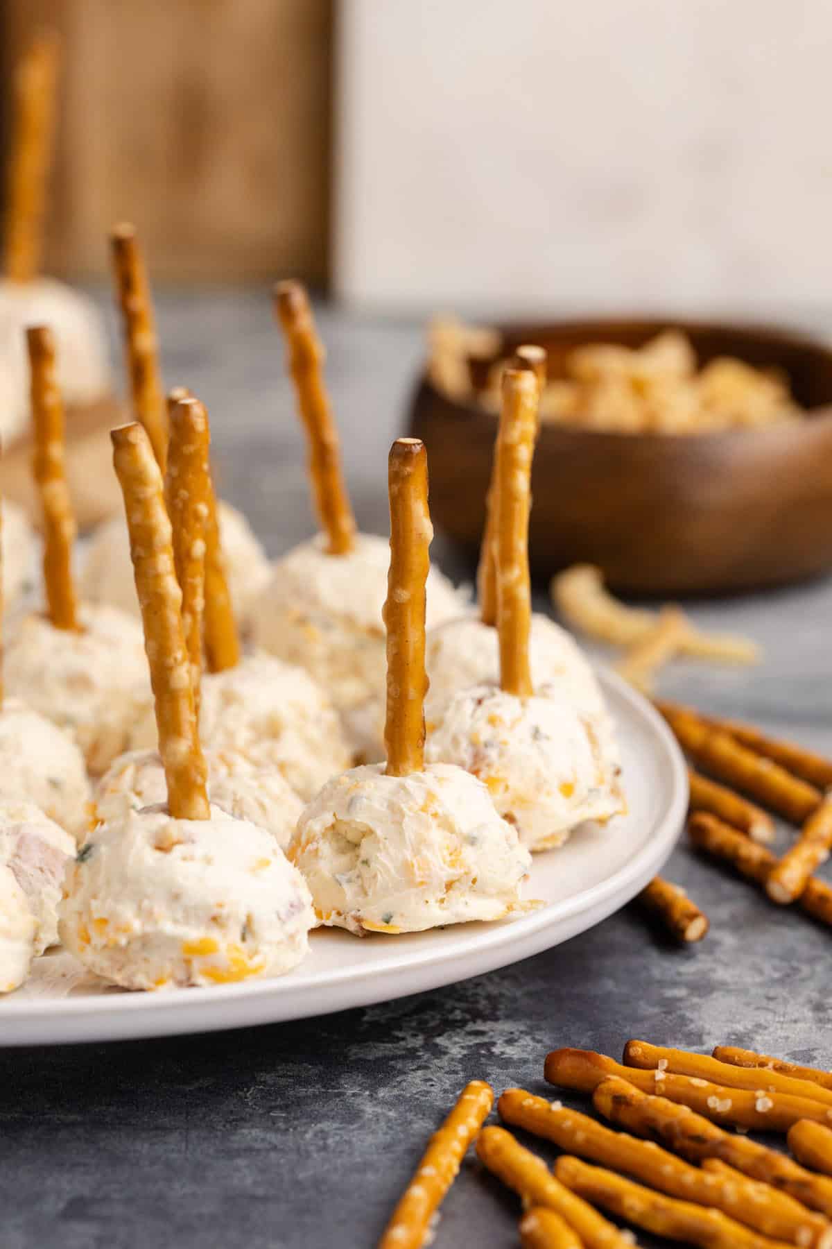 Mini Cheese Balls close up on a plate with pretzels beside