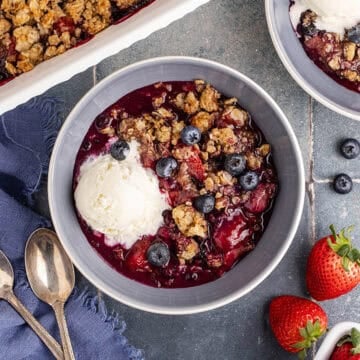 Mixed Berry Crisp with Frozen Berries close up in a bowl with ice cream