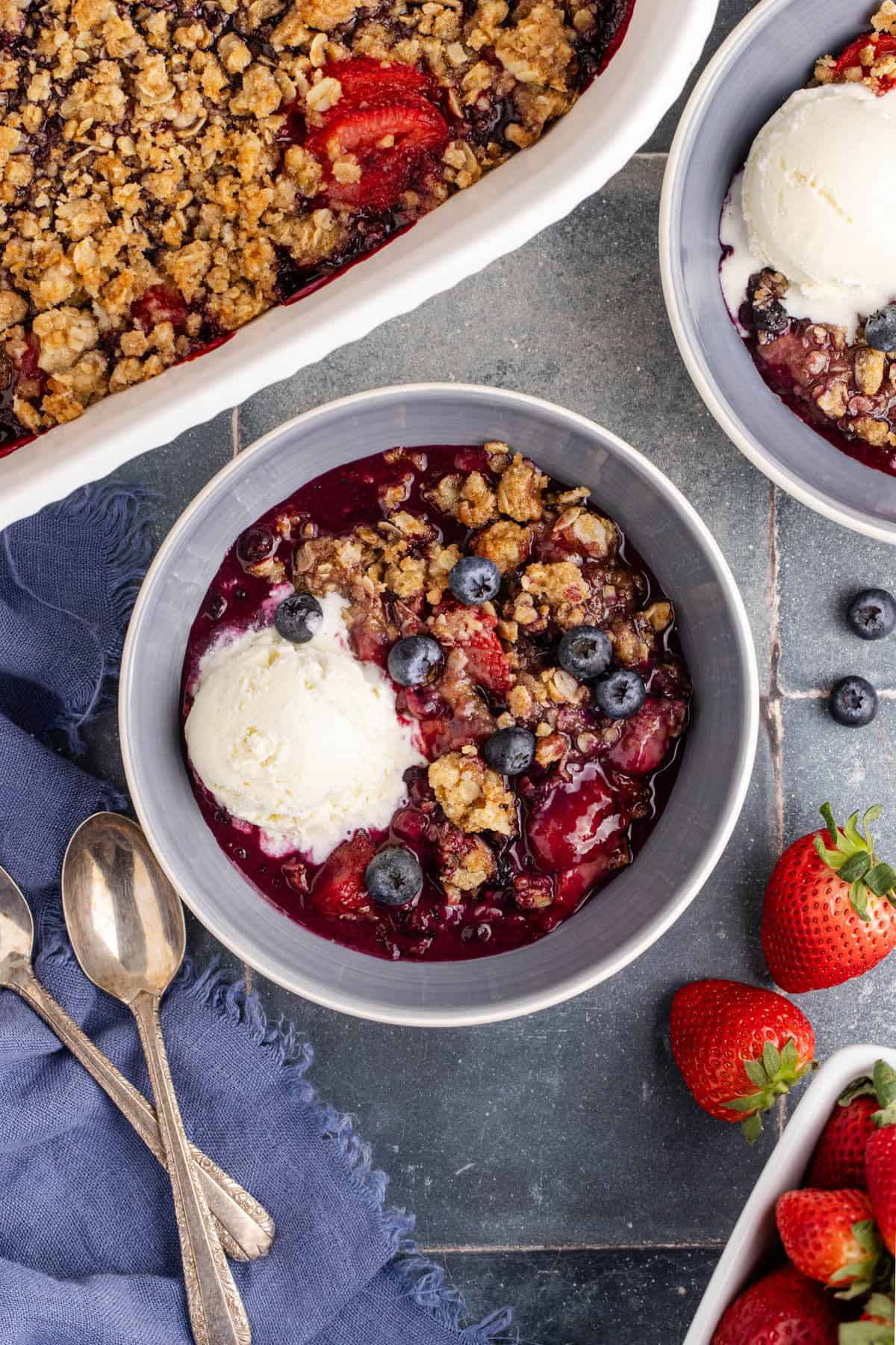Mixed Berry Crisp with Frozen Berries in a bowl with ice cream and fresh blueberries on top