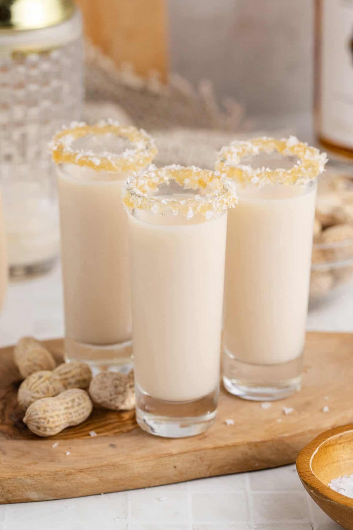 Salted Nut Roll Shots on a tray with peanuts beside