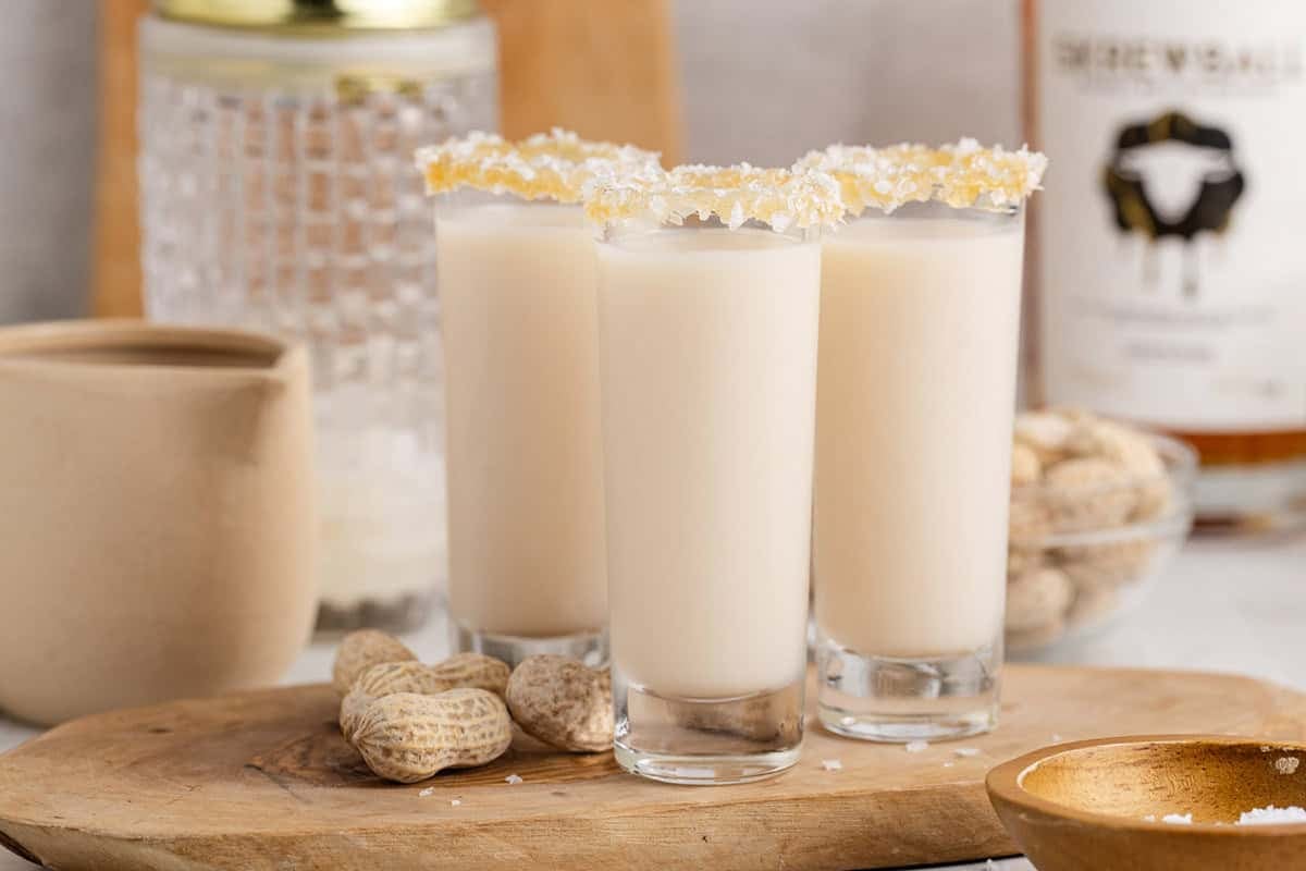 Salted Nut Roll Shots on a tray with peanut butter whiskey in the back