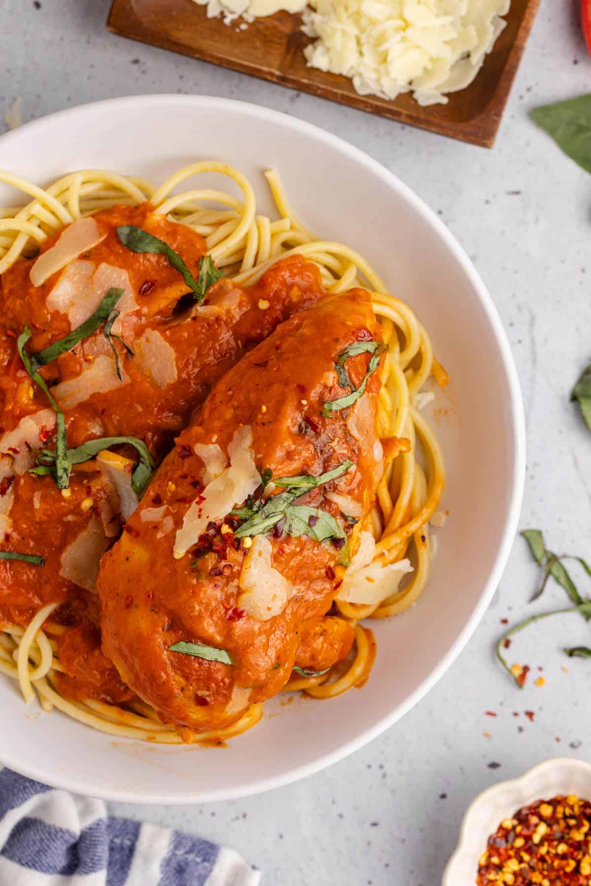 Tomato Basil Chicken plated with basil and parmesan cheese close up