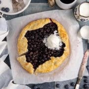 Blueberry Galette with Ice Cream scooped onto it with a slice slightly removed