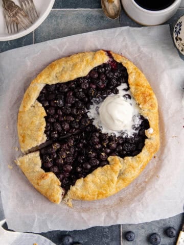 Blueberry Galette with Ice Cream scooped onto it with a slice slightly removed