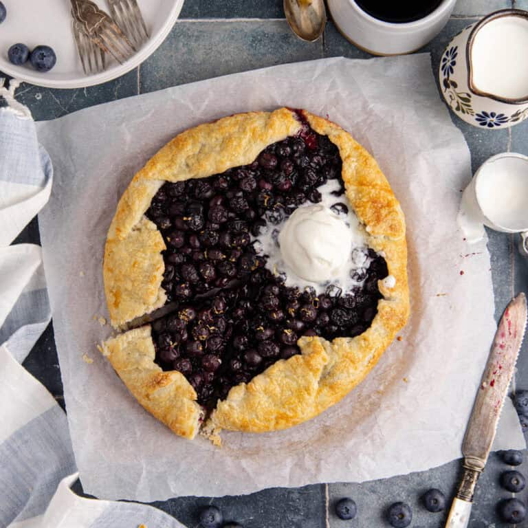 Blueberry Galette with Ice Cream scooped onto it with a slice slightly removed
