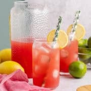 Watermelon Juice Served in Glass Over Ice with Lemon Slice and Paper Straws