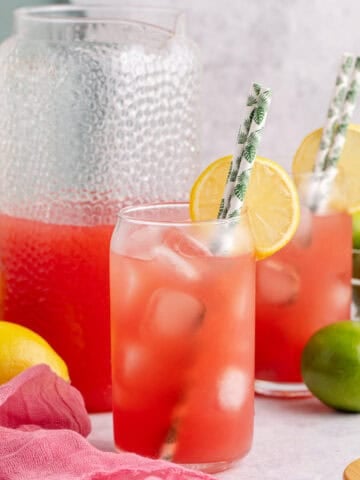Watermelon Juice Served in Glass Over Ice with Lemon Slice and Paper Straws