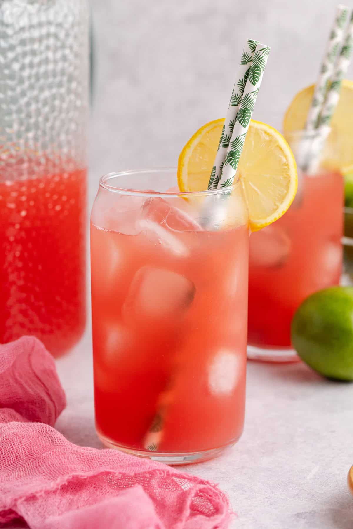 Watermelon Juice Served in Glass Over Ice with Lemon Slice and Paper Straws