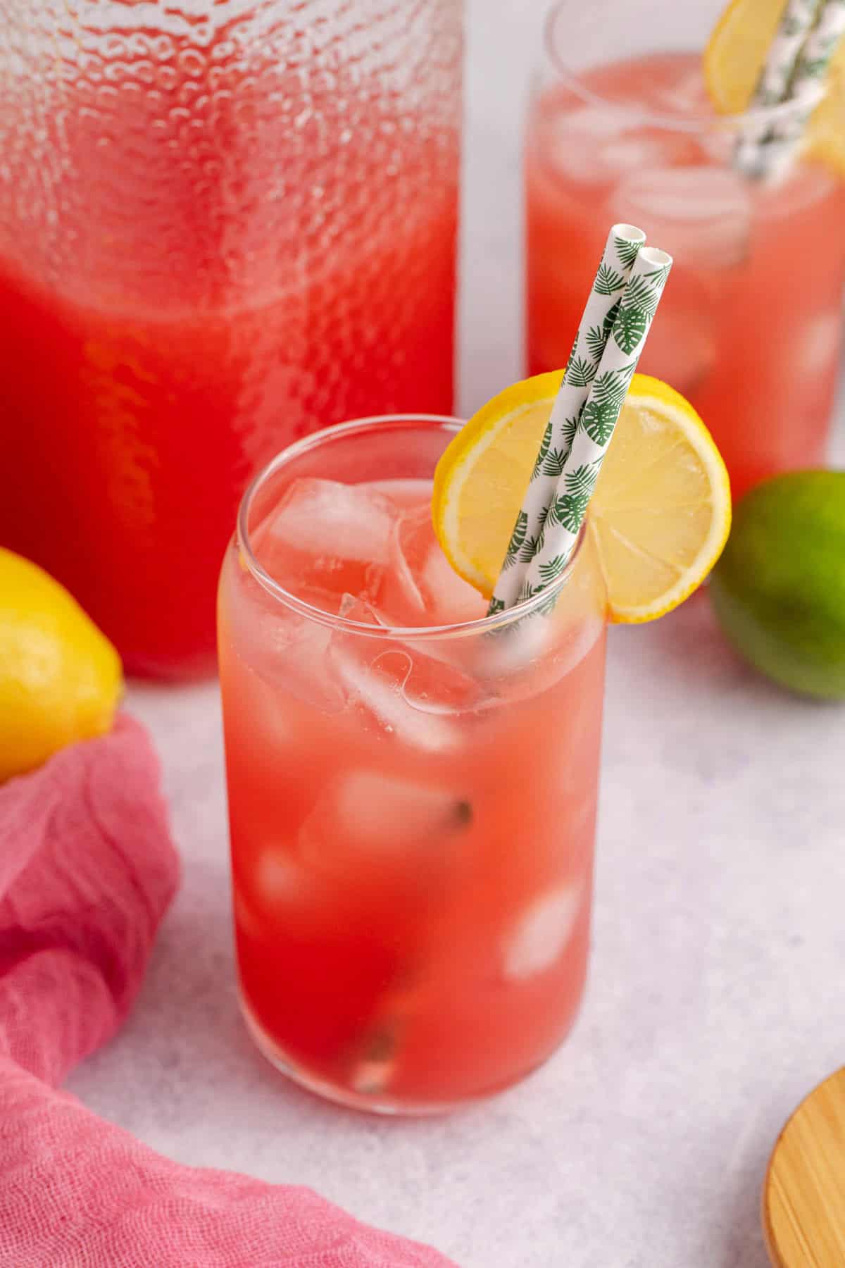 Watermelon Juice Served in Glass Over Ice with Lemon Slice and Paper Straws
