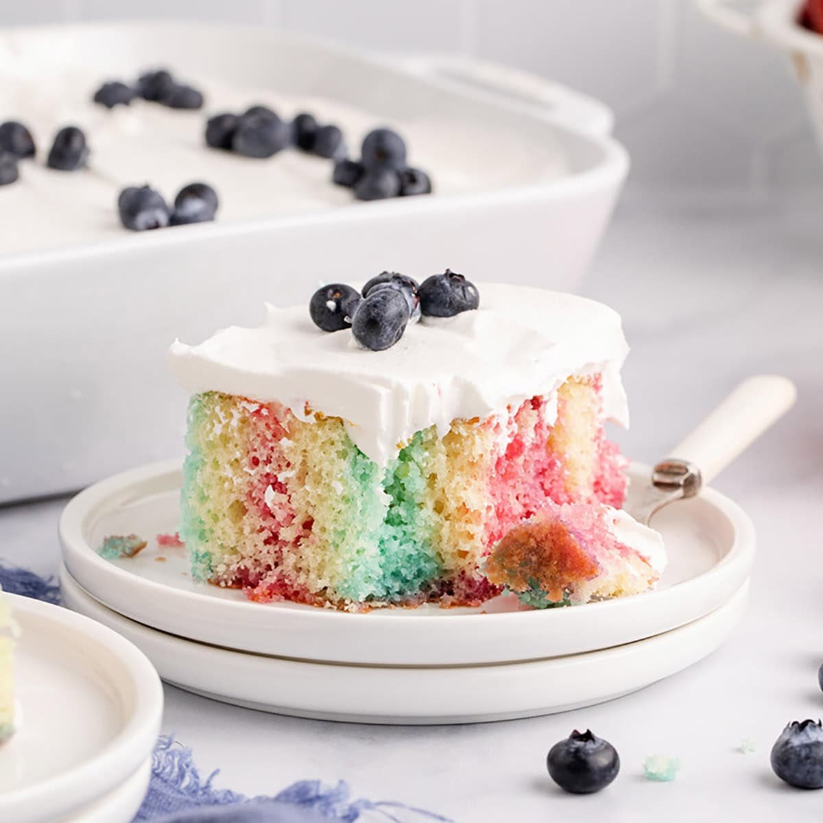 Red, White and Blue Cake slice on a plate with icing and blueberries