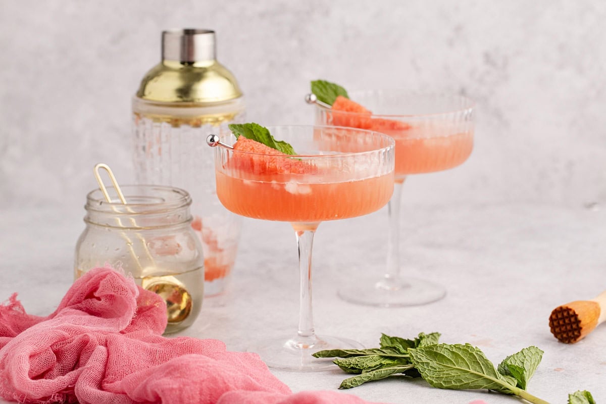 Watermelon Sour Served in Coupe with Watermelon Cube and Mint Leaf Garnish
