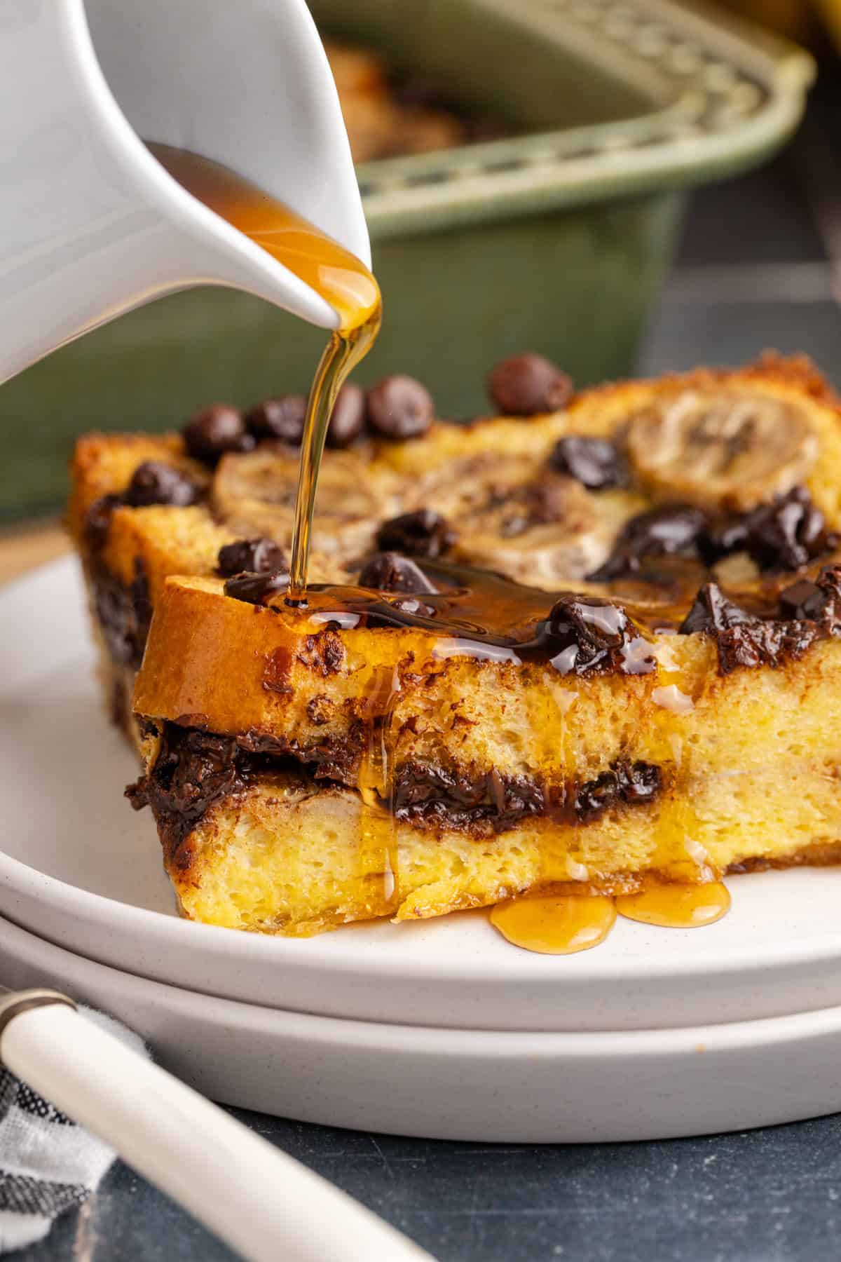 Banana French Toast Casserole close up on a plate pouring syrup on top