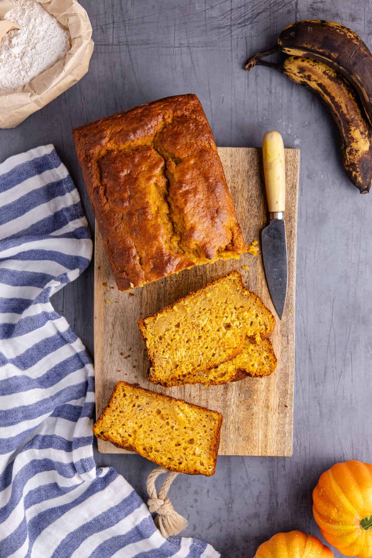 Pumpkin Banana Bread on a Cutting Board with a few slices taken