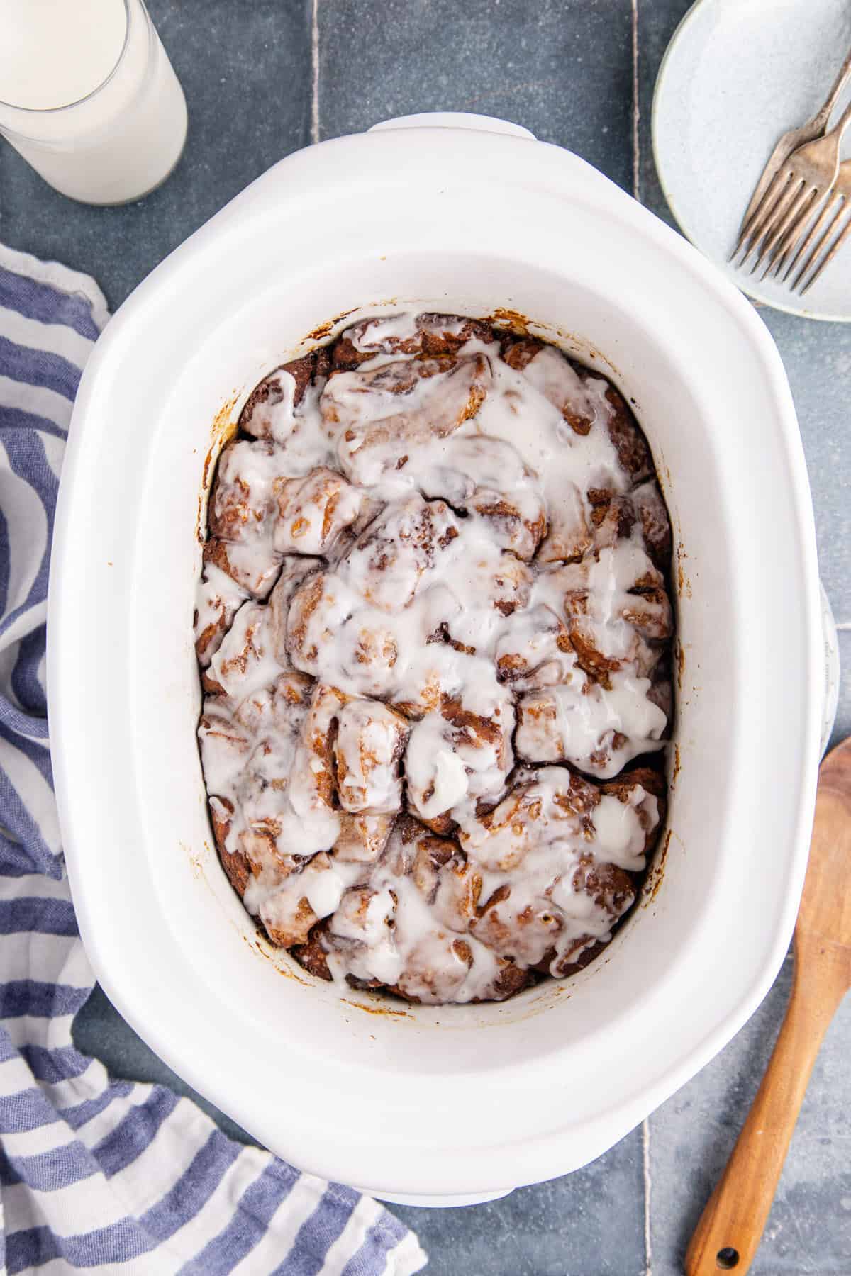 Overhead View of Cinnamon Bun Casserole with Icing In Crock Pot
