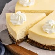 Eggnog Cheesecake Garnished with Whipped Cream and Sliced on Cake Server