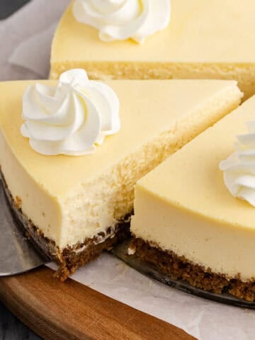 Eggnog Cheesecake Garnished with Whipped Cream and Sliced on Cake Server