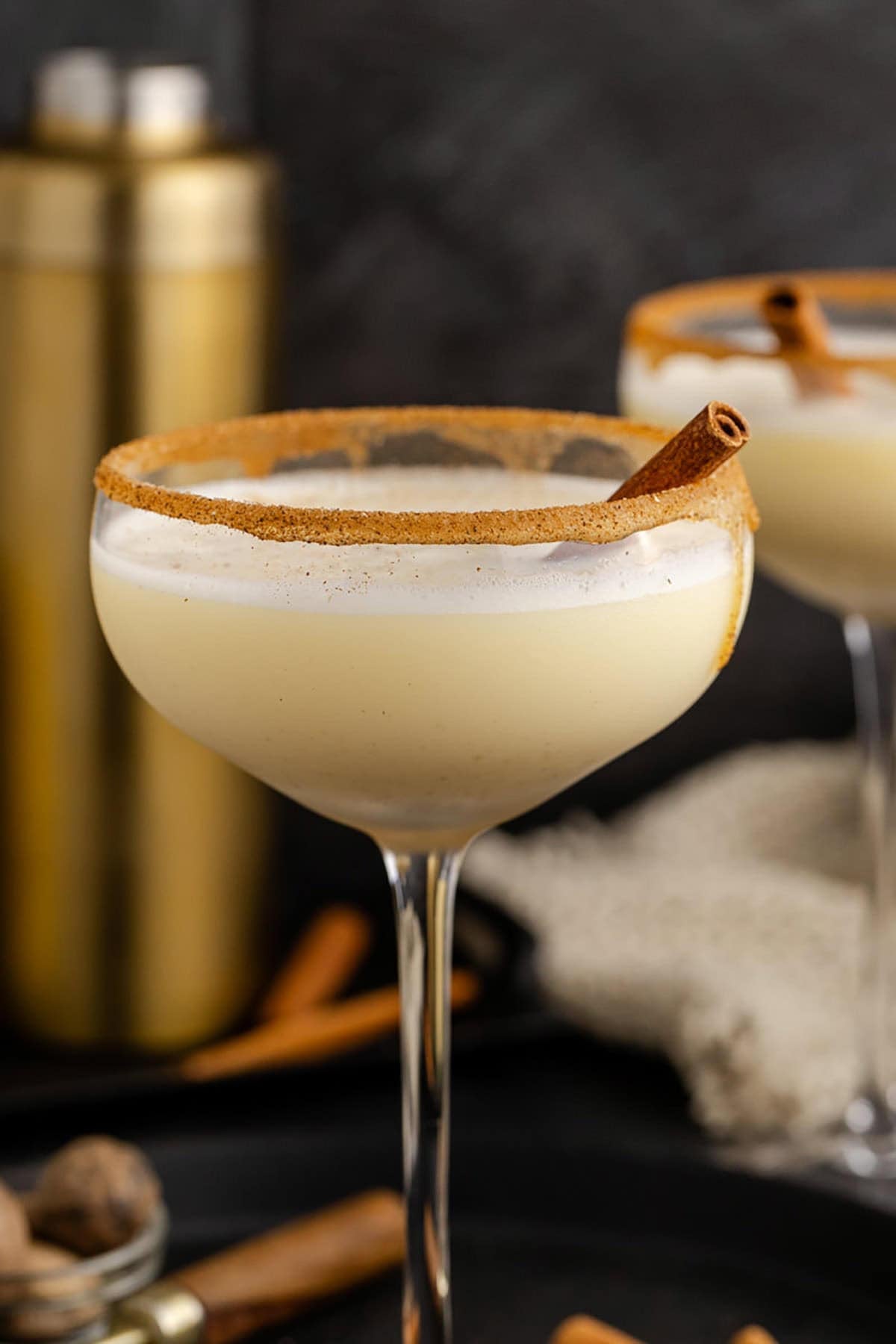 Eggnog Martini Cocktails Garnished with Cinnamon Sticks and Cinnamon Sugar Rim