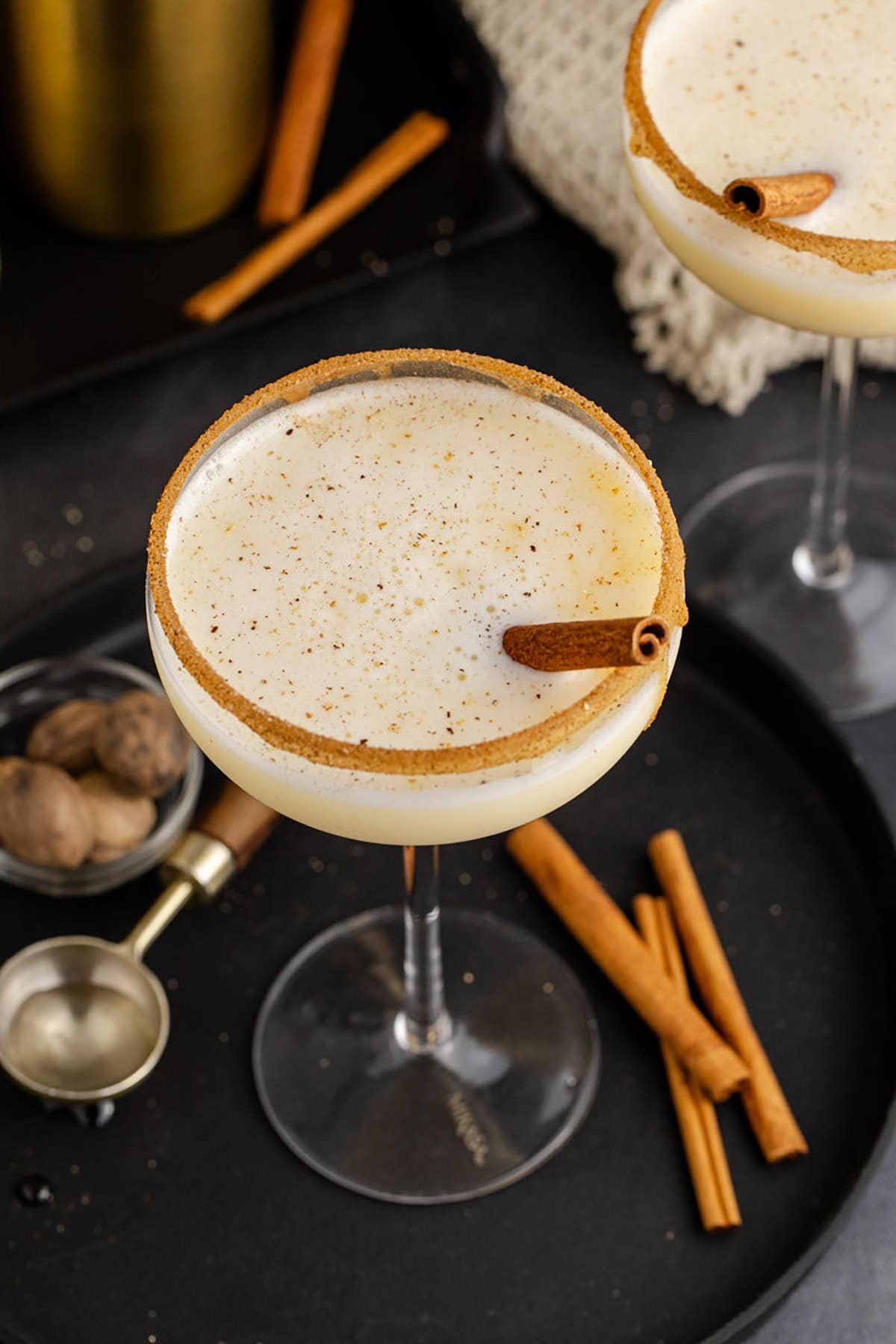 Eggnog Martini Cocktails Garnished with Cinnamon Sticks and Cinnamon Sugar Rim