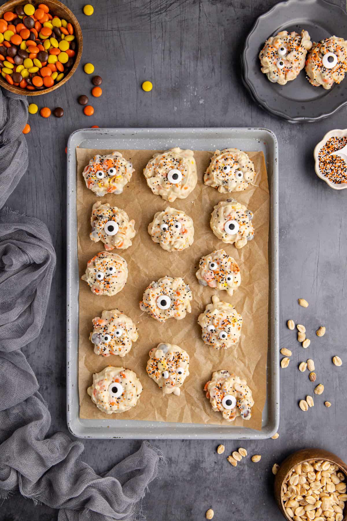 White Chocolate Peanut Halloween Crockpot Candy with Halloween Sprinkles and Edible Eyeballs on Parchment Lined Baking Sheet