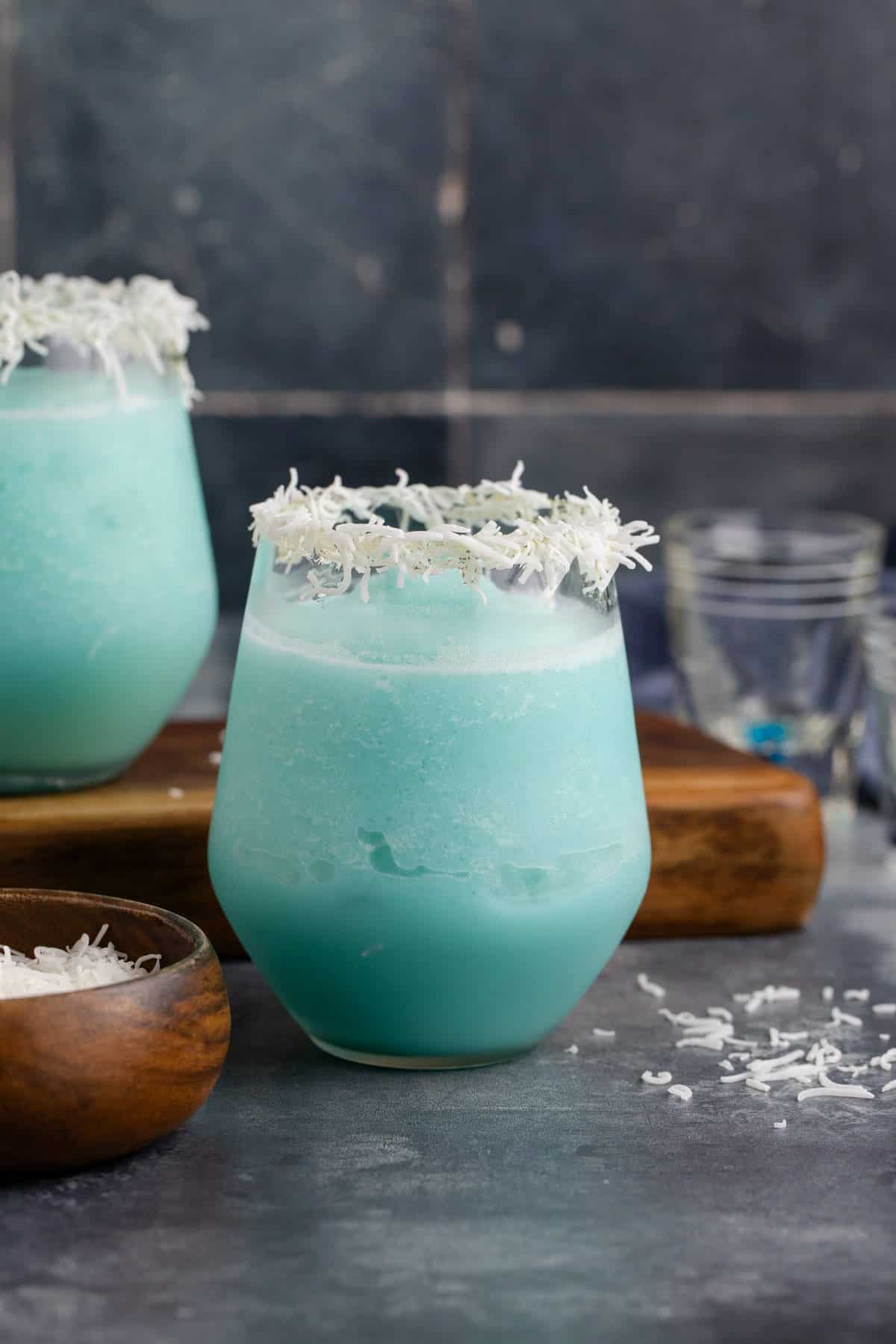 Jack Frost Cocktail in a Clear Glass Garnished with Shredded Coconut Rim