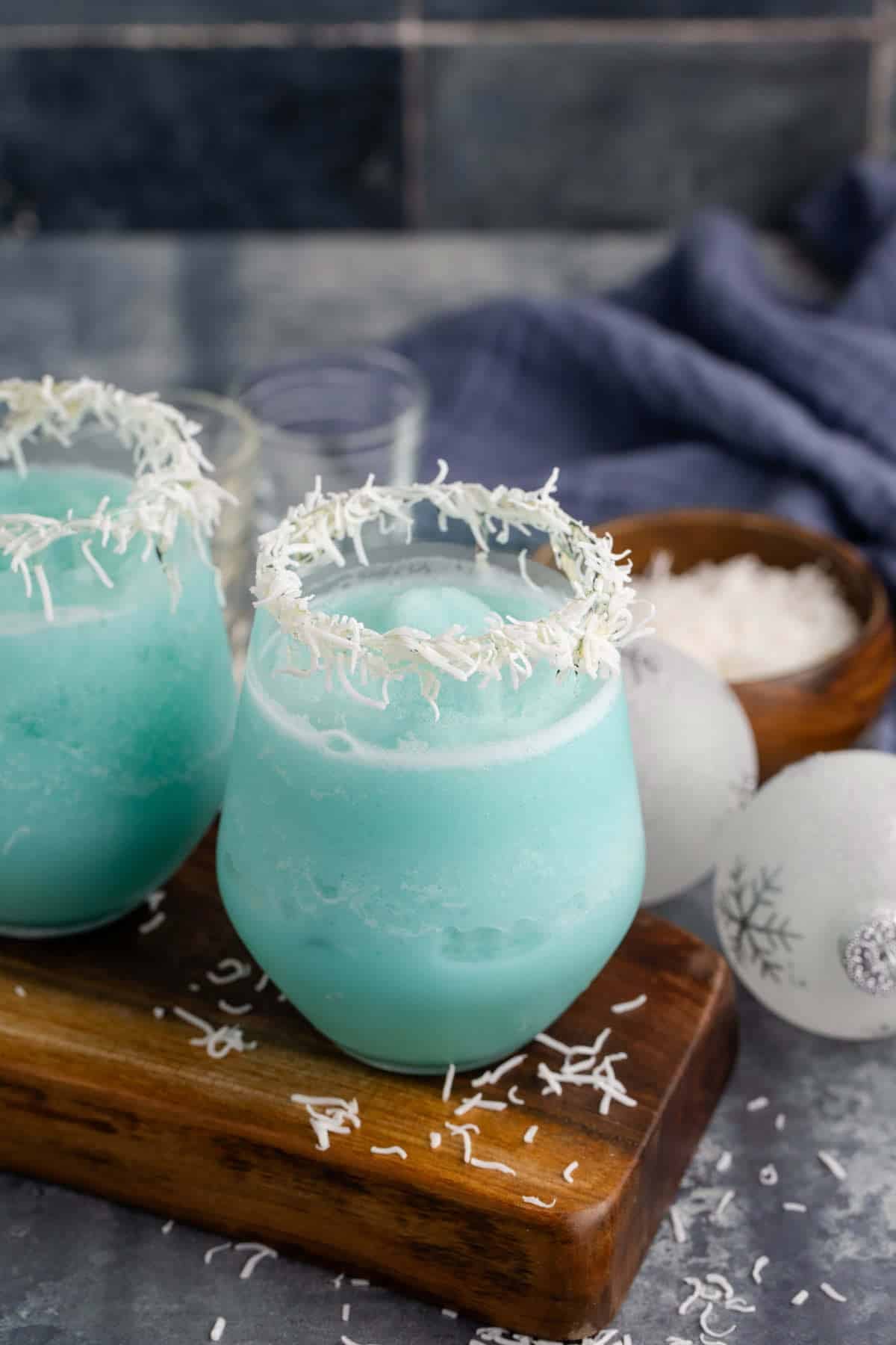 Blue Jack Frost Cocktail in a Clear Glass Garnished with Shredded Coconut Rim