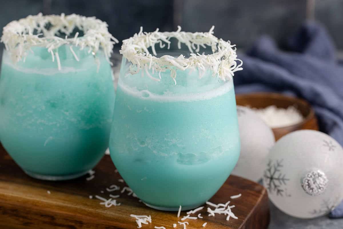 Jack Frost Cocktail in a Clear Glass Garnished with Shredded Coconut Rim
