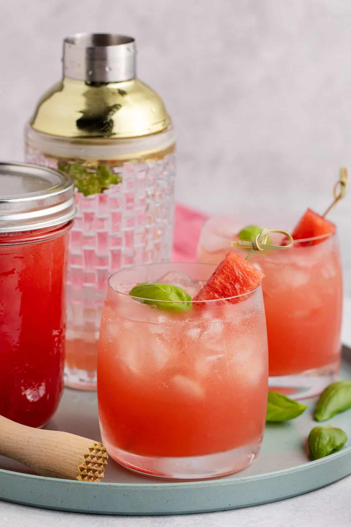 Watermelon Basil Margarita on a tray with watermelon juice and cocktail shaker