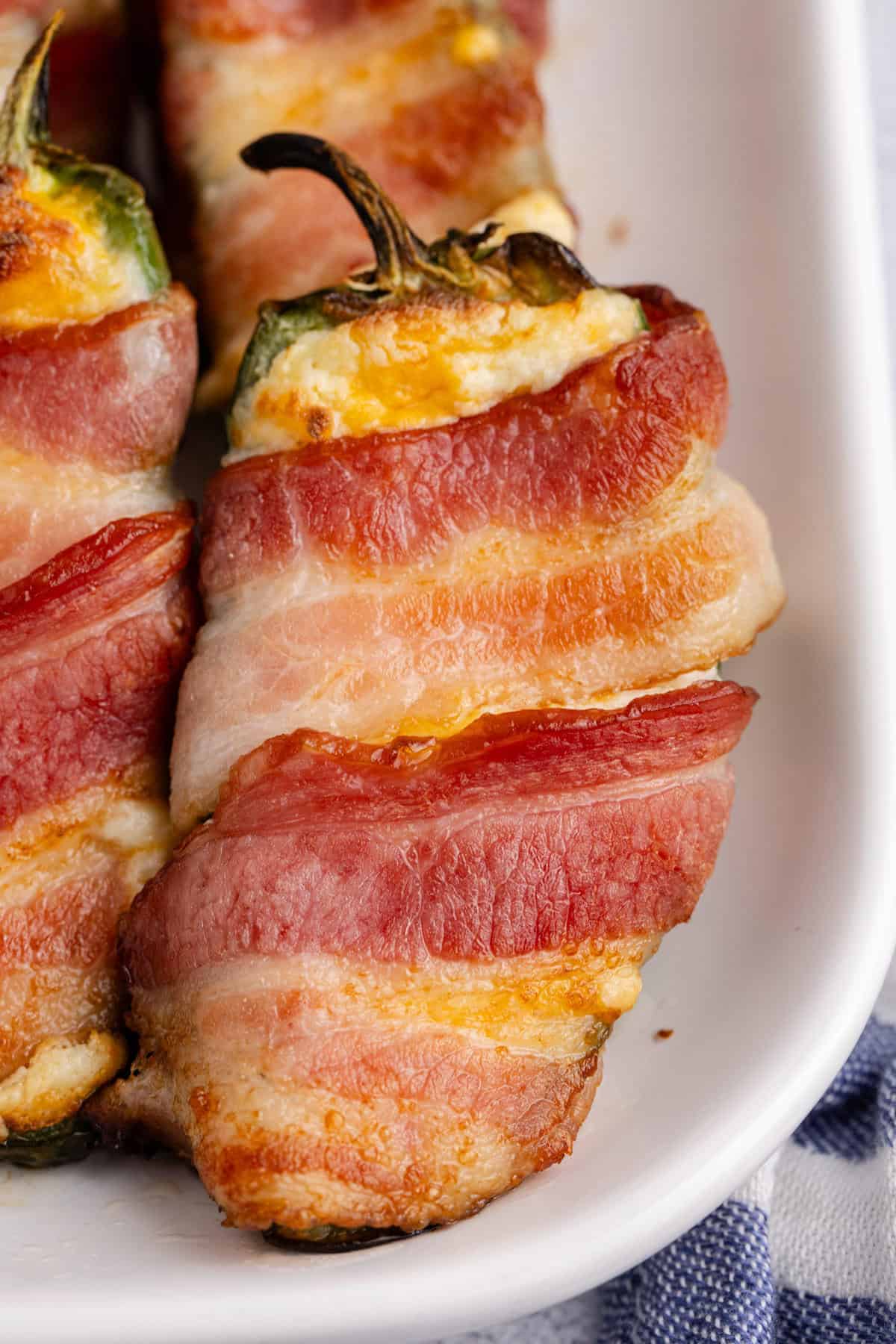 Bacon Wrapped Jalapeno Poppers baked and on a tray close up