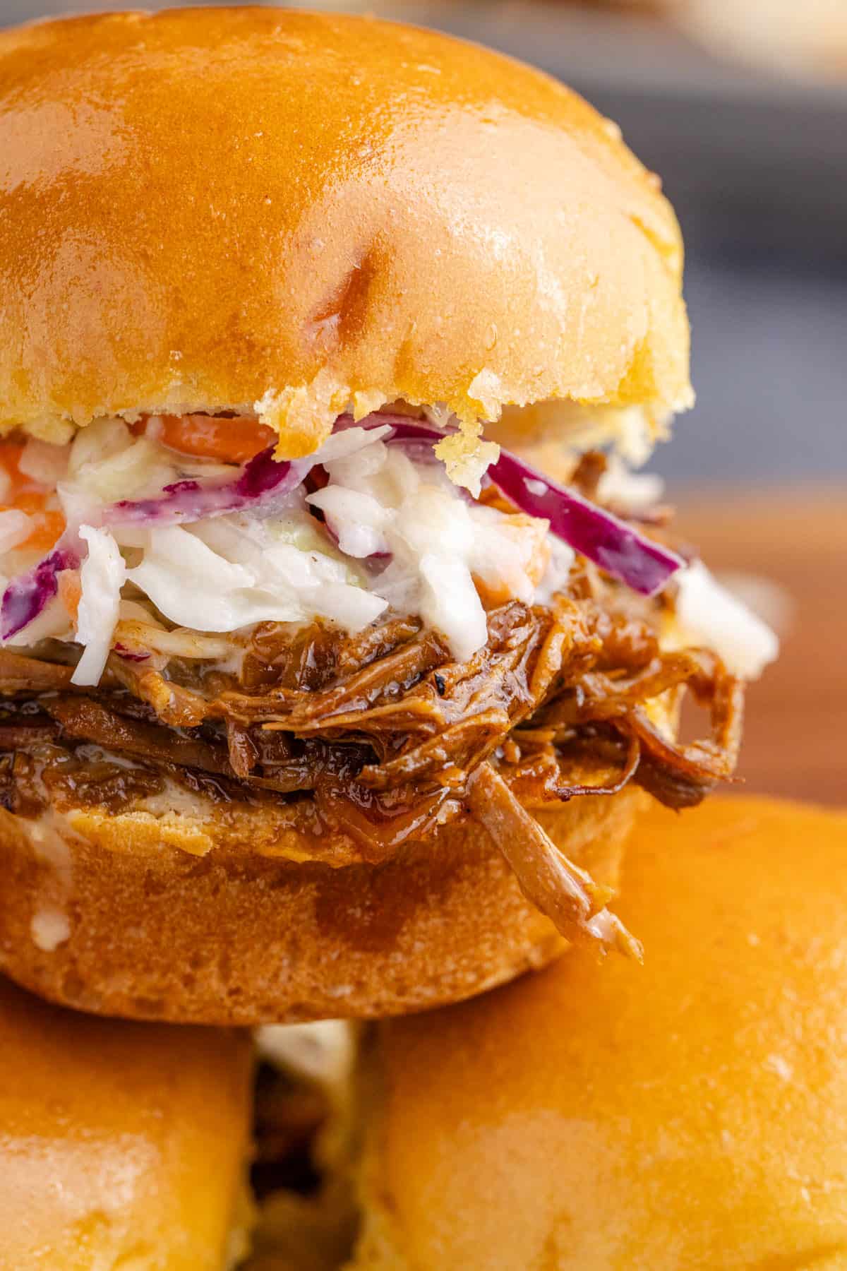 Brisket Sliders stacked on a cutting board close up